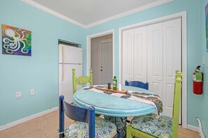 A dining area with a round table, chairs, and a white door in the background. - Mermaid Hideaway | Quaint & Affordable Tropical Getaway! (Cheriton)