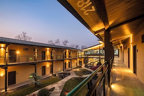 A multi-story hotel with a covered outdoor area, a central courtyard, and a staircase leading to the upper floors. - Cloud View Wild Hotel (Xianyang)