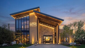 A modern building with large windows, a stone facade, and a sign that reads 'YUNMAN BOGENGY.' - Cloud View Wild Hotel (Xianyang)