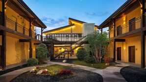 A modern hotel with a central courtyard, outdoor seating, and a staircase leading to the upper levels. - Cloud View Wild Hotel (Xianyang)