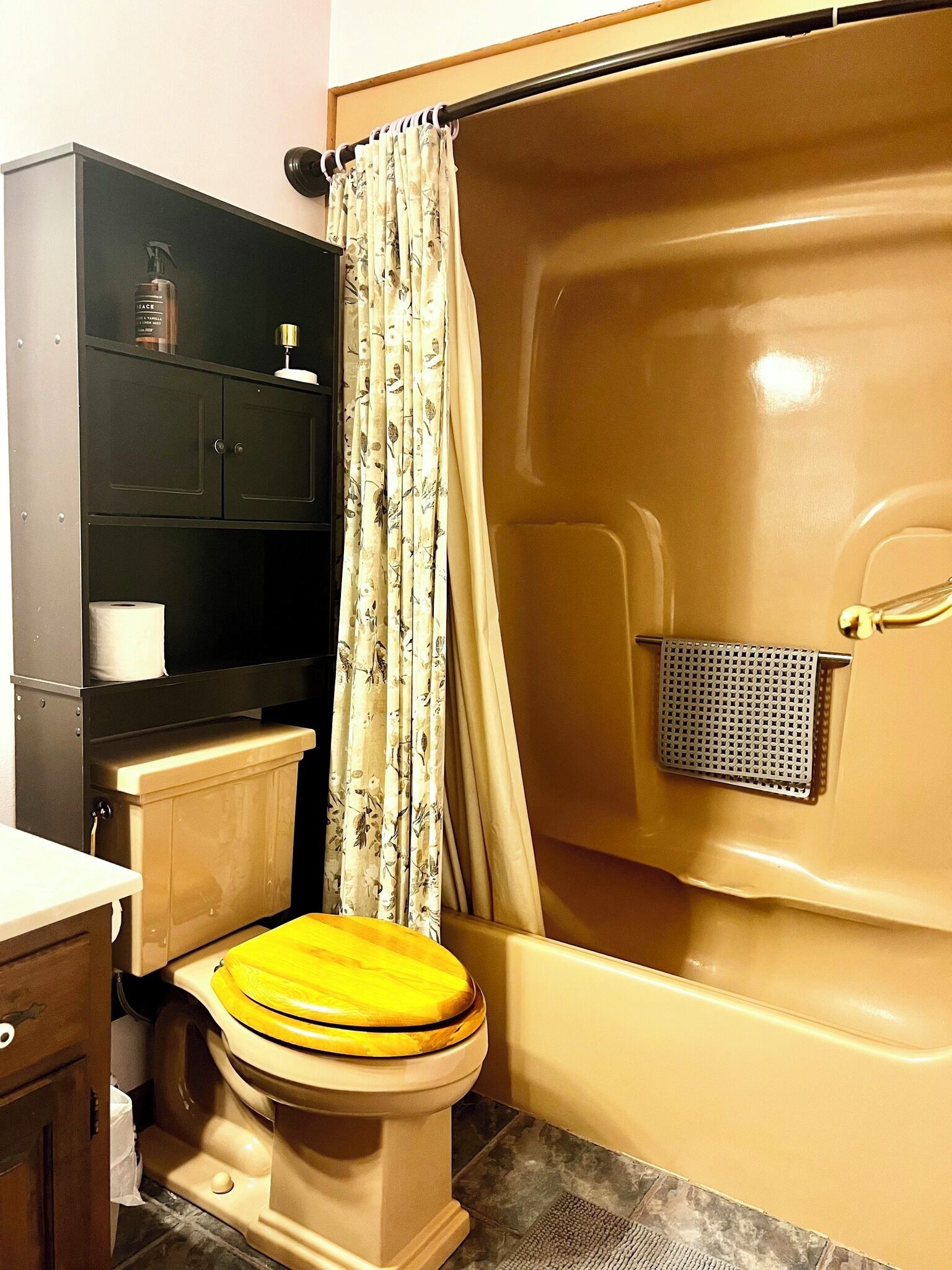 Une salle de bain comprenant des toilettes, une douche, un lavabo et un meuble de rangement.