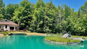 A swimming pool with a wooden deck and a house in the background.
