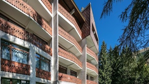 A multi-story building with balconies, large windows, and a surrounding fence. - Alpine Studio in Central Setting (Les Deux Alpes)