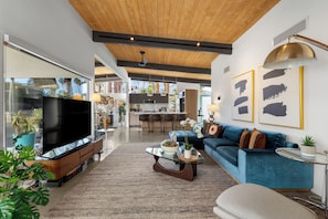 A modern living room with a TV, sofa, coffee table, and artwork. - Hollywood Hideaway - 1959 Alexander (Palm Springs)