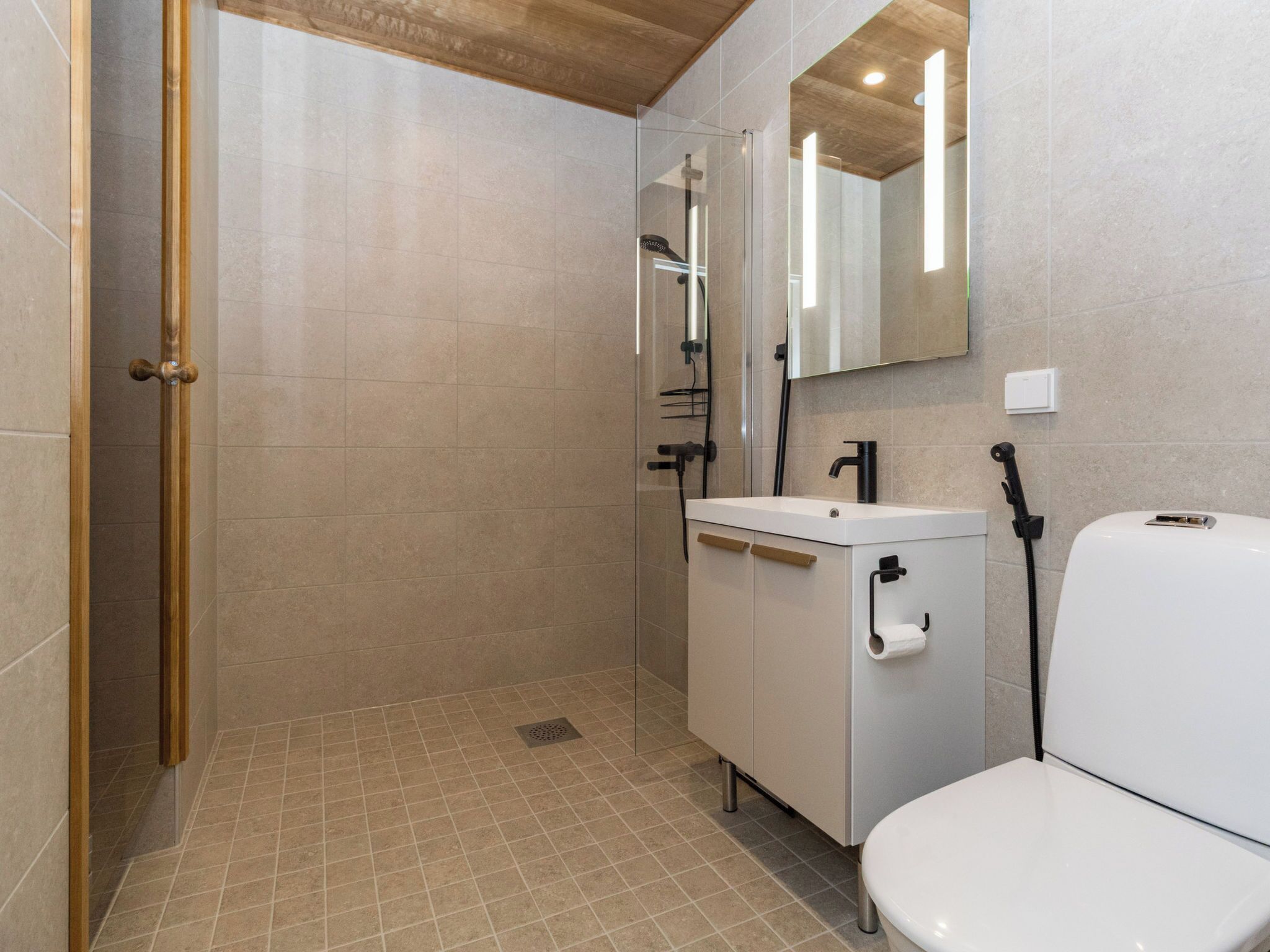Une salle de bain avec douche, toilettes et lavabo.