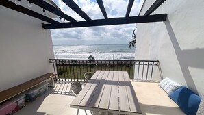 Un balcon avec vue sur l’océan, une table et une chaise.