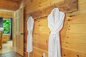 A wooden interior with two white robes hanging on hooks. - Honeymoon Ridge- Luxury Mountaintop Cabin (Bryson City)