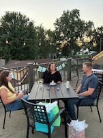 Un patio al aire libre con una mesa, sillas y un cartel de cumpleaños.