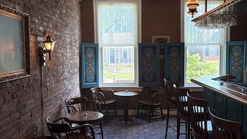 A room with brick walls, a patterned carpet, and a bar area with stools.