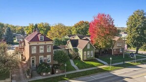 A residential street with houses, a clear sky, and autumn foliage.