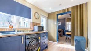 A compact kitchen with a washing machine, a microwave, and a sink.