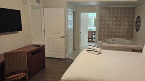 A hotel room with a bed, a television, a desk, a chair, a bathroom with a bathtub, and a shower. - "SALE" Charming 5-bedroom, 5-bathrom resort in fabulous Kissimmee Florida. (Kissimmee)