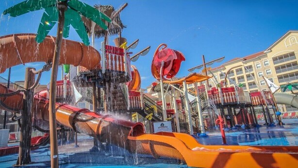 A water park with slides and water features, surrounded by a building with balconies. - "SALE" Charming 5-bedroom, 5-bathrom resort in fabulous Kissimmee Florida. (Kissimmee)