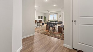 A modern interior with a dining area, kitchen, and a large window.