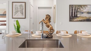 Un espace repas doté d’un îlot central, d’un évier et d’une statue équestre décorative.