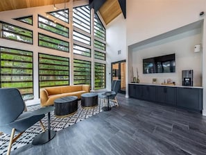 A modern interior with a sofa, chairs, a coffee machine, and a TV. - Spacious 1BR w/ Patio, Pool & Gym Access (Austin)