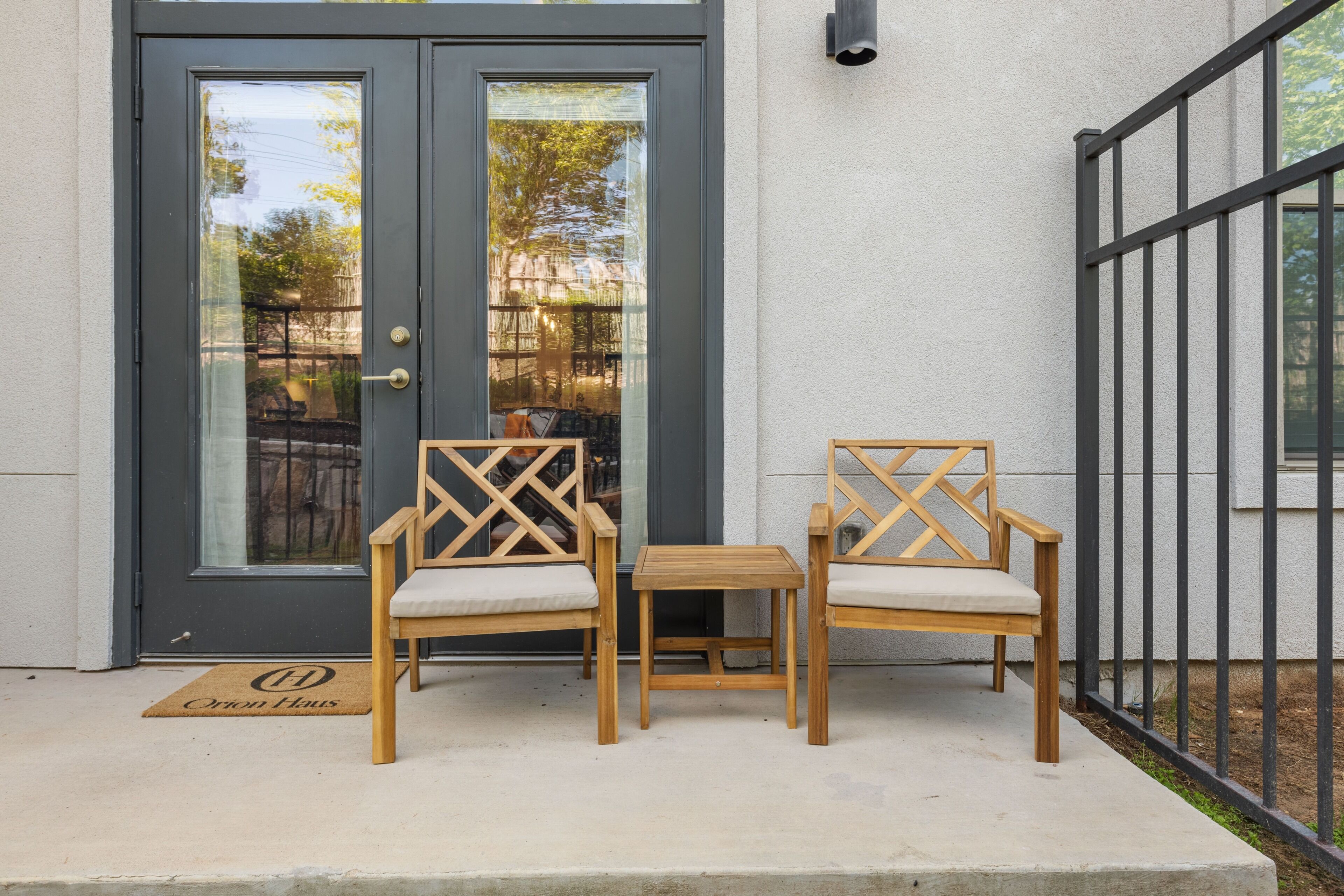 A door with glass panels, two wooden chairs with cushioned seats, and a small wooden table.