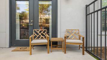 A door with glass panels, two wooden chairs with cushioned seats, and a small wooden table.