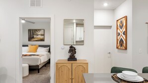 Ein Hotelzimmer mit einem Bett, einem Holzschrank, einem Esstisch mit Unterlage und einem Spiegel an der Wand.
