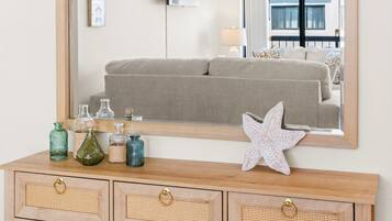 A wooden console table with three drawers, a mirror, and decorative items including a starfish.