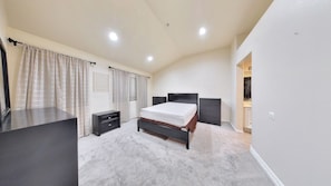 Ein Schlafzimmer mit Bett, Schminktisch, Nachttisch, Kleiderschrank und einem durchgegangenen Tür angedeuteten Badezimmer.