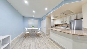 A modern kitchen with white cabinets, stainless steel appliances, and a granite countertop. -     Fully Furnished Anaheim Townhome - Utilities Included - Gated Community (Anaheim)