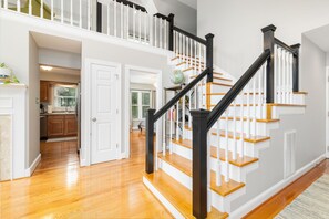 A staircase with white railings and wooden steps, leading to a second floor. - Lakefront, Dock, Slide, Tiki Bar, Kayaks, Fire pit, Pet Friendly (Bracey)