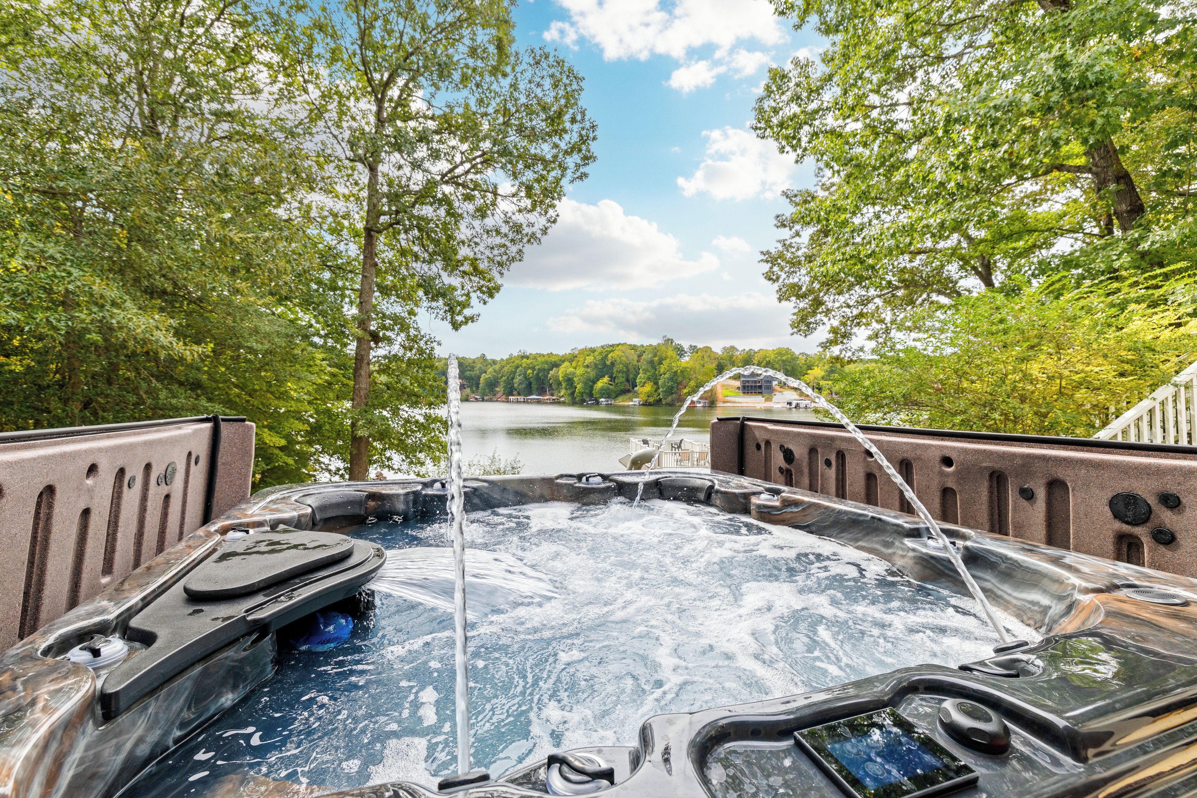 A hot tub with a view of a lake and trees.