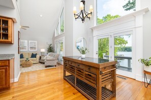A spacious living area with a wooden coffee table, a sofa, and a dining table. - Lakefront, Dock, Slide, Tiki Bar, Kayaks, Fire pit, Pet Friendly (Bracey)