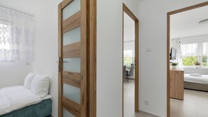 Une chambre moderne avec un lit, une porte en bois et une vue sur une autre pièce qui comprend un coin repas.