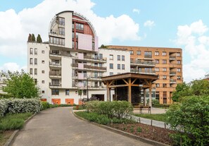 A multi-story residential building with balconies, a covered outdoor seating area, and a landscaped garden. - Park Praski Homely Apartment (Warszawa)