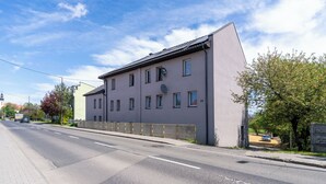Un edificio a più piani con tetto piatto e diverse finestre, con un'antenna parabolica ben visibile.