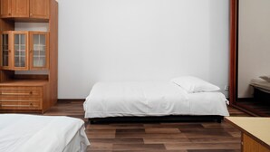 Een slaapkamer met een bed, een houten garderobe en een spiegel.