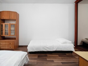 Ein Schlafzimmer mit einem Bett, einem Holzschrank und einem Spiegel.