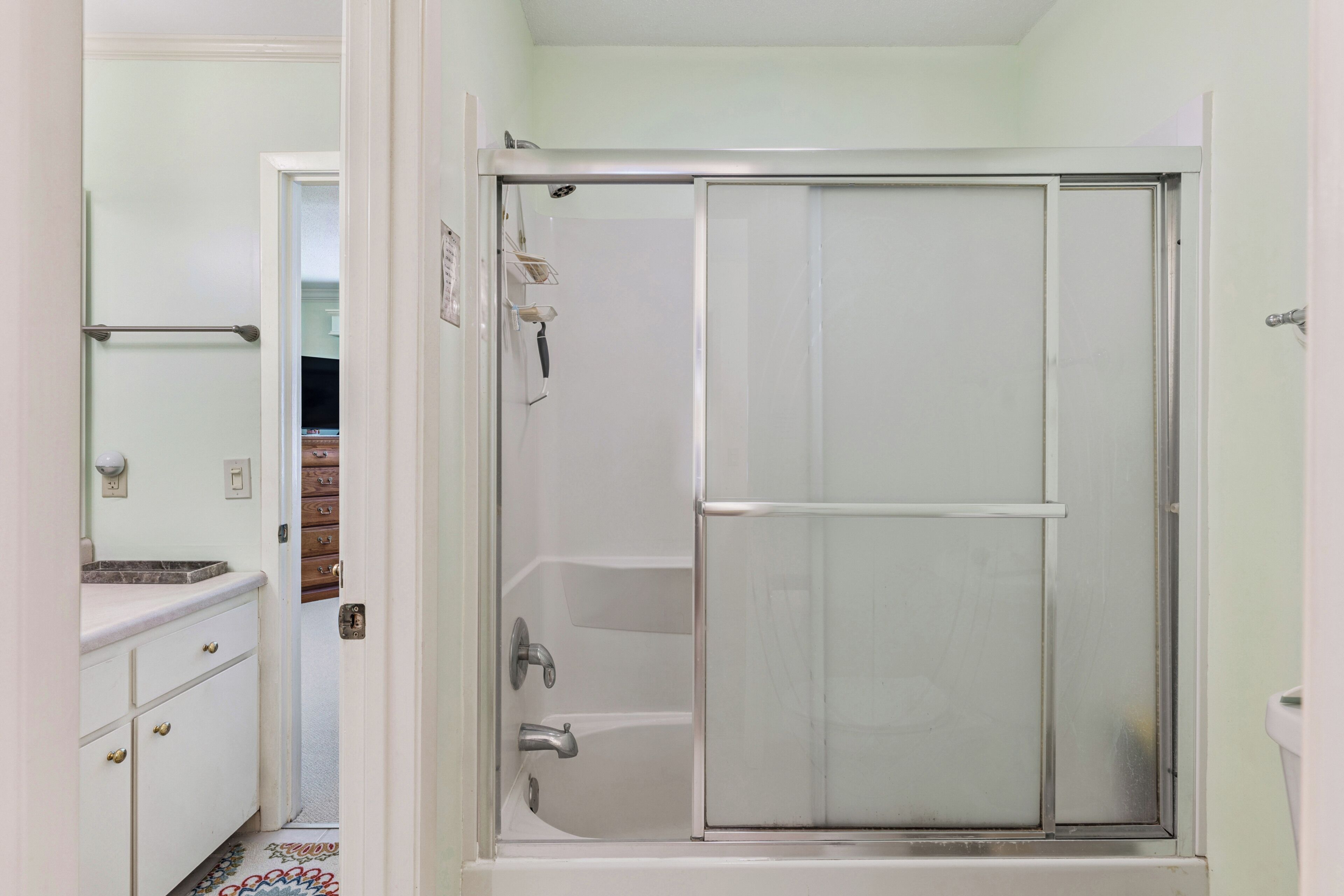 A bathroom with a shower, a toilet, and a sink.