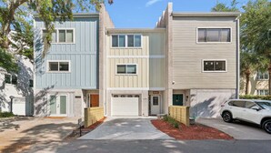 A row of townhouses with a garage, a driveway, and a parked SUV. - Coastal St. Simons Retreat | Private Patio + Bonus Suite (Saint Simons Island)