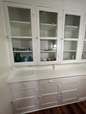 A white bathroom vanity with a sink, three cabinets, and a mirror. - Spacious 3BR Niagara Stay + Backyard (Niagara Falls)