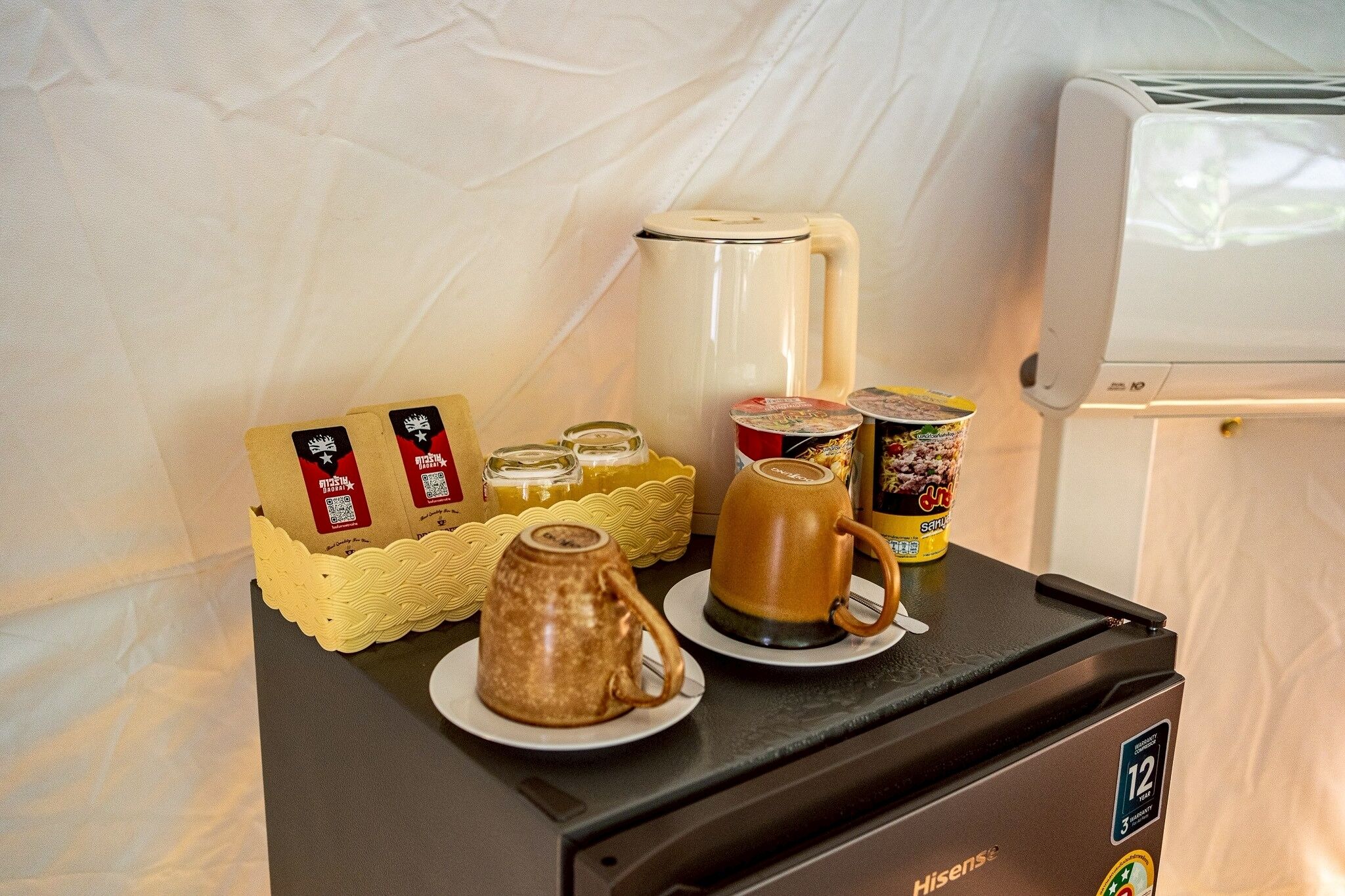 Eine Küchenzeile mit Kaffeemaschine, Toaster, Tasse, Marmeladenglas und einer Packung Teebeuteln.