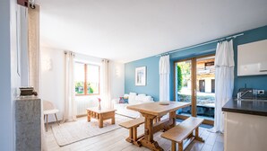 Een moderne keuken met een houten tafel, een witte bank en uitzicht op de omgeving.