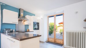 Een moderne keuken met witte kasten, een roestvrijstalen afzuigkap en een inbouwoven.