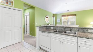 A kitchen with white cabinets, a granite countertop, and a double sink. - Family Friendly Ocean Keyes 4431 Halftime at the Beach (North Myrtle Beach)