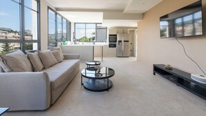 Un salon moderne avec un canapé, une table basse et un téléviseur fixé au mur.