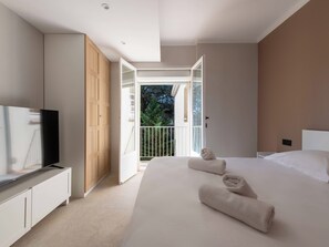 Ein Schlafzimmer mit Bett, Fernseher, Kleiderschrank und Balkon.