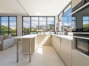 Eine moderne Küche mit großen Fenstern, einem Essbereich und Blick auf die Stadt.