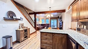 A kitchen with wooden cabinets, a granite countertop, and a stainless steel dishwasher. - The Timberline Haus - Where Pines Meet The Payette (McCall)