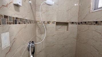 Een douche, handdoeken, zeep, toiletpapier