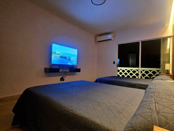 Een hotelkamer met een bed, een aan de muur bevestigde televisie en een raam met uitzicht.