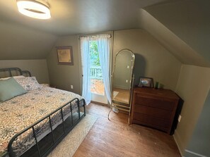 A bedroom with a bed, a dresser, a mirror, and a window with curtains. - Charming 3-bedroom house in State College (State College)