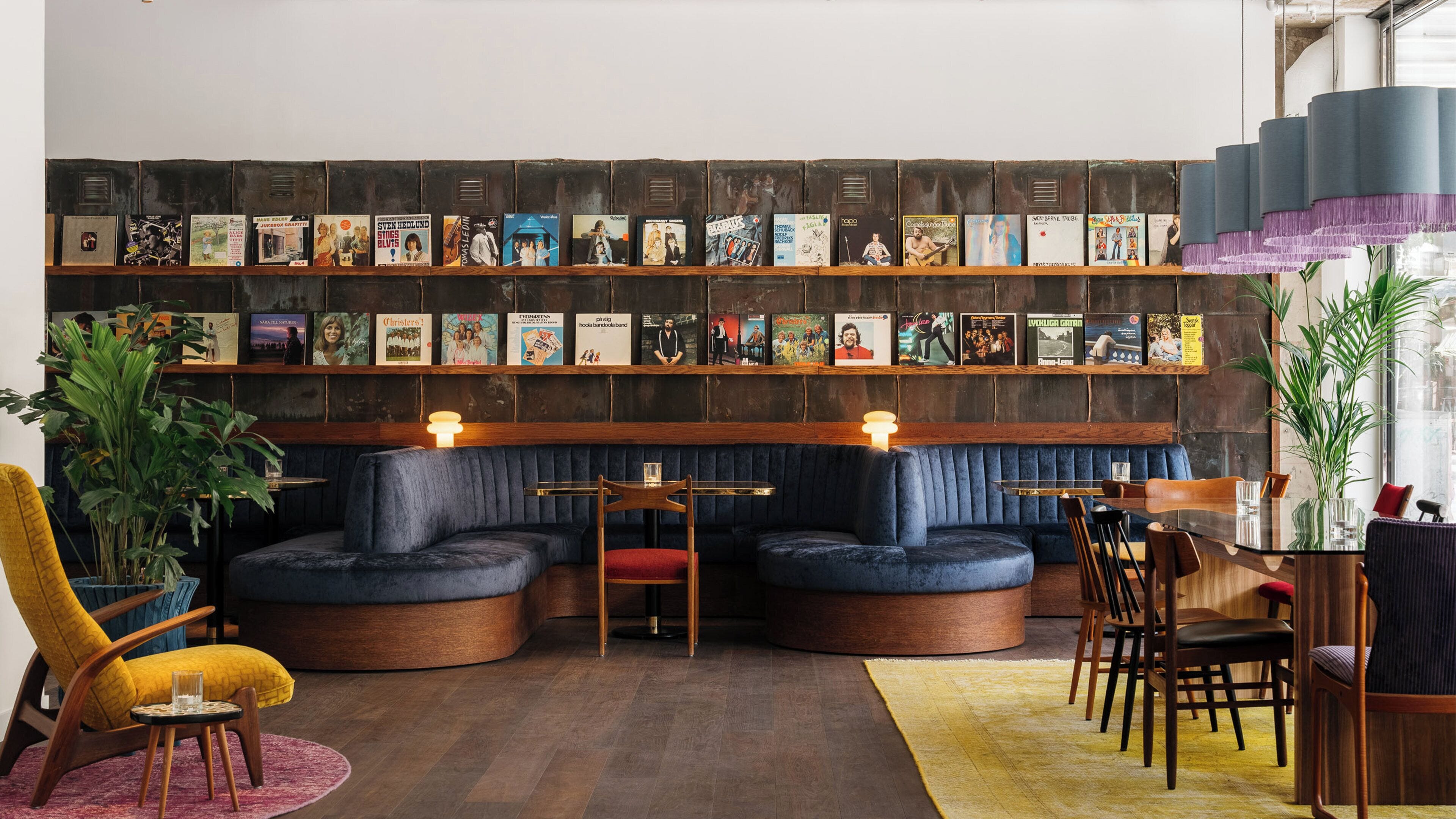 A cozy seating area with a bookshelf displaying various books and albums.