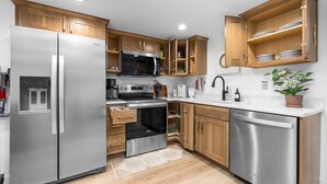 Una cucina moderna con elettrodomestici in acciaio inossidabile, mobili in legno e forno integrato.